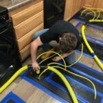 FloodCo technician Nick installing drying mats at water remediation site
