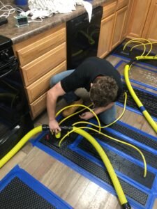 FloodCo technician Nick installing drying mats at water remediation site