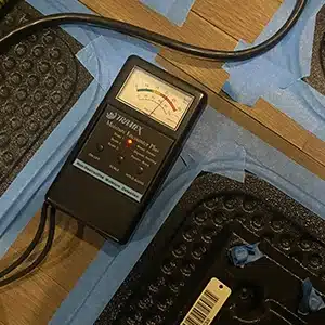 Moisture meter on red indicating wet floors. Best to completely dry to prevent mold damage that commonly occurs after the incident.