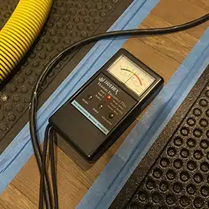 moisture meter on yellow, indicating that the floors are successfully drying